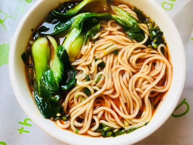 然后舀少许面汤在料碗里，再捞面条
