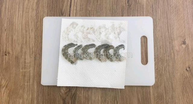 用纸巾吸走虾仁的水分。