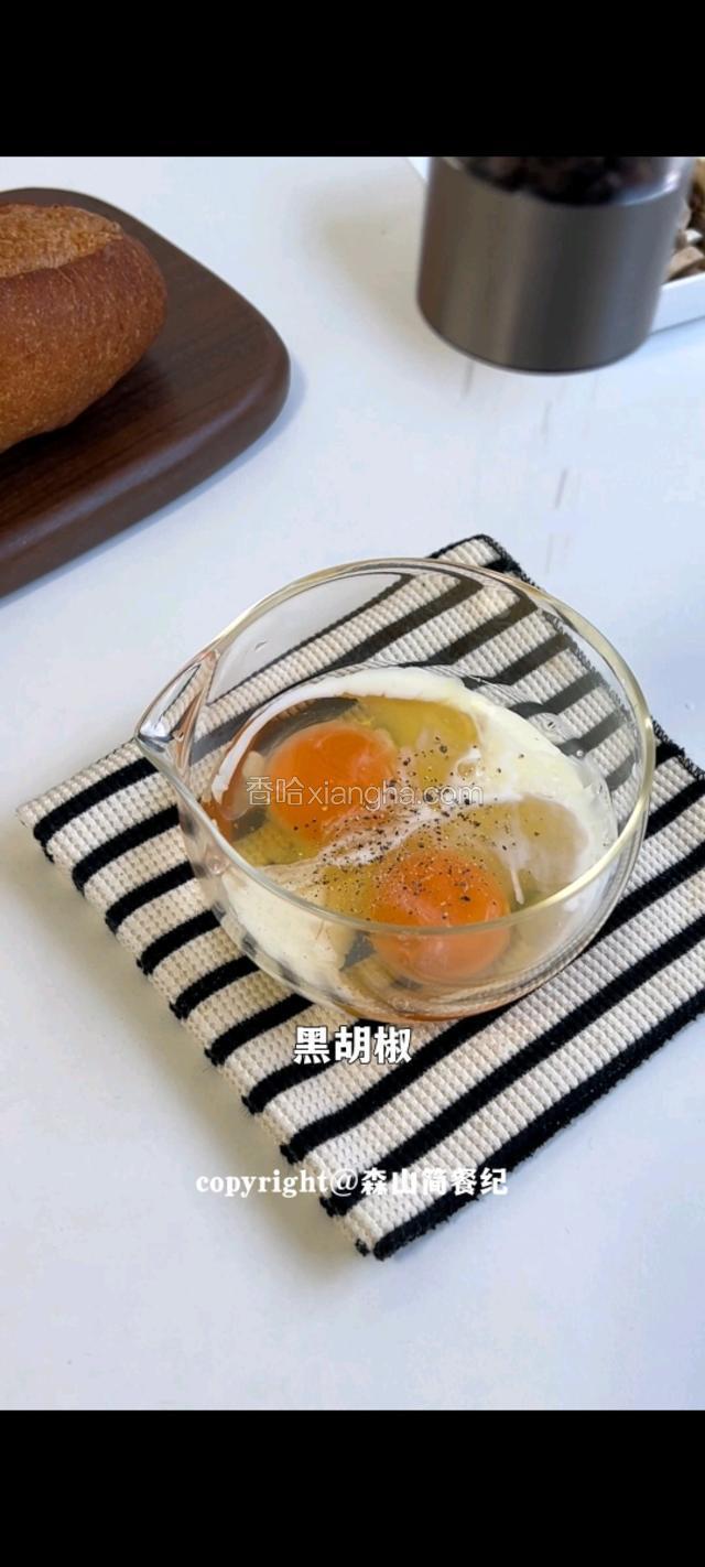 碗中打两个鸡蛋，撒黑胡椒搅拌均匀。