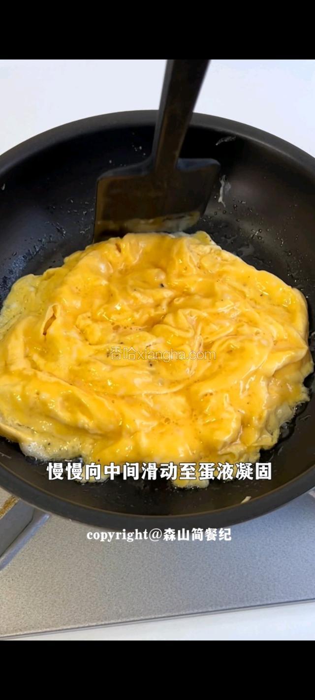 油热倒入蛋液，慢慢向中间滑至蛋液凝固。
