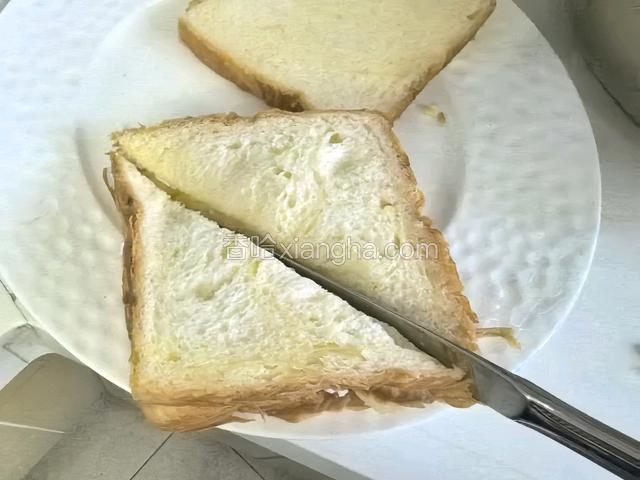 重叠好后用餐刀把它对半切成三角形。