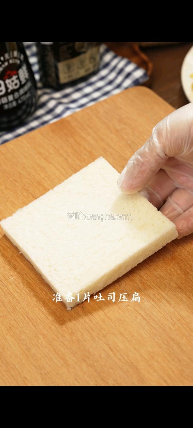 准备一片吐司压扁。放上合适的芝士片。铺上虾滑。