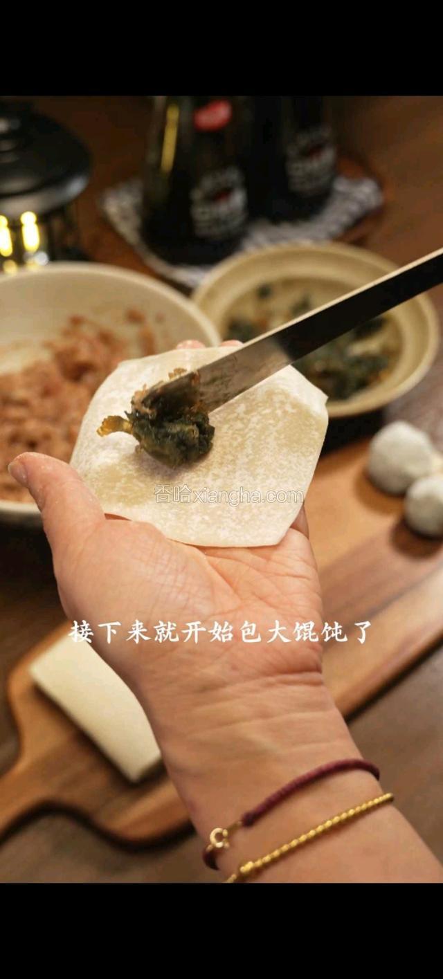 接下来就开始包大馄饨了。一勺皮蛋，一勺肉馅，轻轻一捏即可。