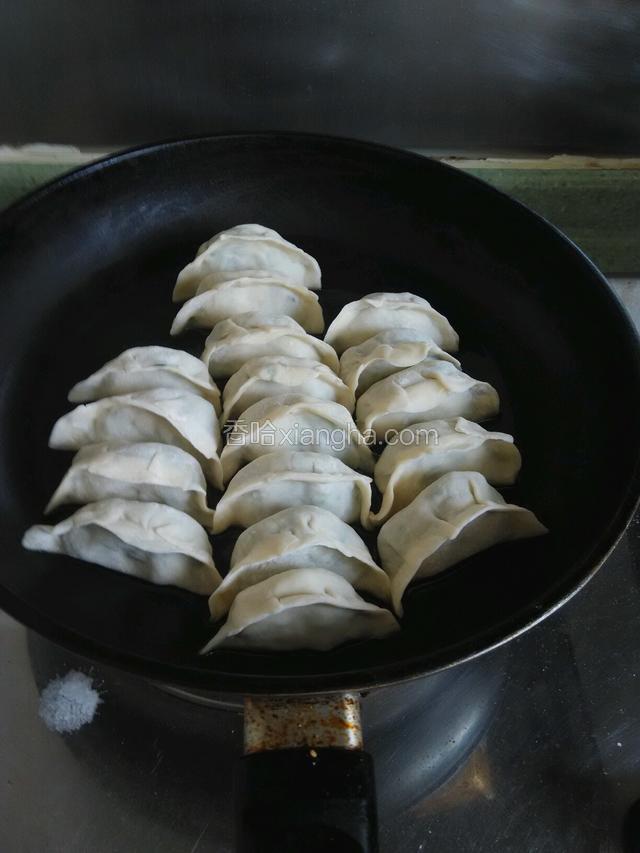 平底锅上火（开中火）加入适量植物油，将饺子摆放在平底锅中。