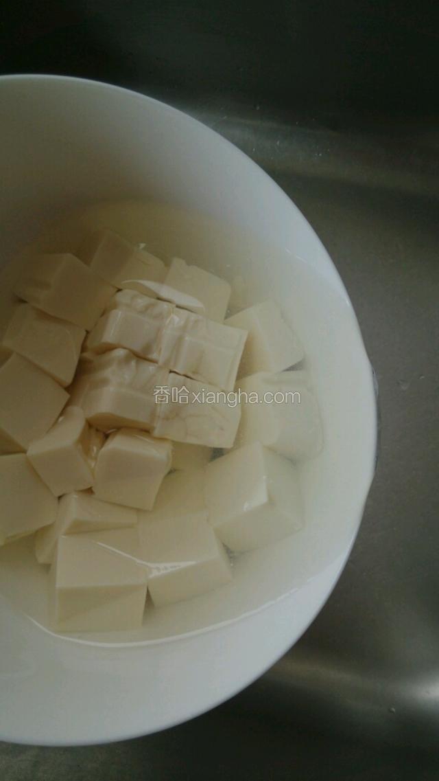 把豆腐倒入碗中用开水过一下，去豆腥味
