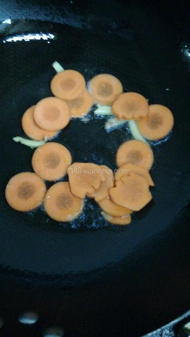 取锅，加油少量，待油热加入姜丝爆香后加入胡萝卜片煸炒。