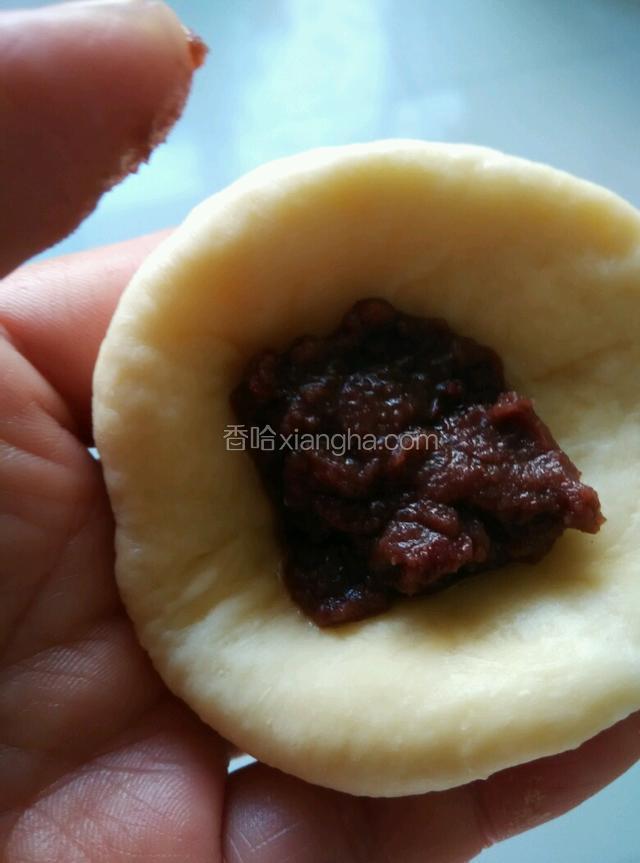 把发酵好的面团排出空气，分成18个小面团，揉圆包上豆沙。