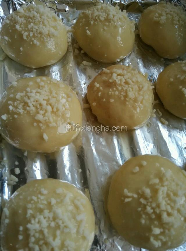 面团包好后排入烤盘，在面包表面刷一层溶化的热猪油，在面团表面撒上一层雪花酥蓉。