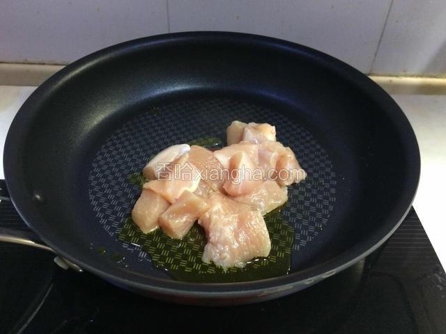 炒锅入油，烧热加入鸡块翻炒。