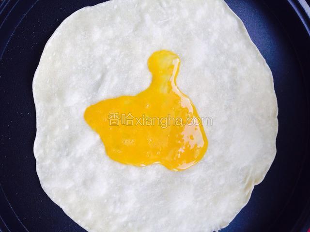 预热好的电饼铛放入一张薄面皮，倒入打散的鸡蛋液，摊均匀，20秒后取出。