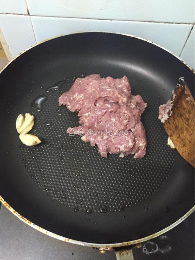 放下适量的油，放蒜头爆香之后放猪肉碎炒至3分钟。
