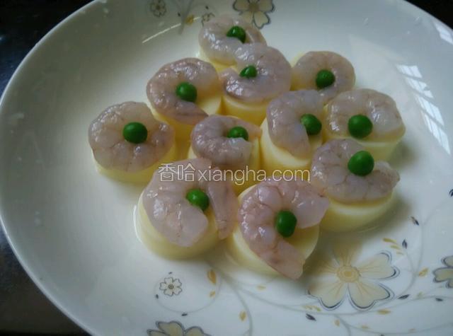 把玉子豆腐切成厚度均匀的长度！摆在盘子里！上面放虾仁，青豆！