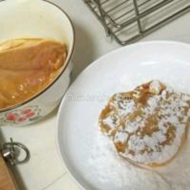 煸葱油时可以继续处理大排。大排腌制后倒出多余料酒和血水，倒入蛋液抓匀，然后放入淀粉盘上粉。