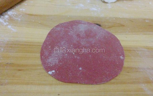 取红色面团，用擀面杖擀成饺子皮的厚度