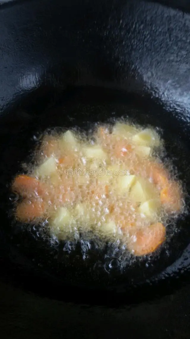 锅中加适量油，先炸胡萝卜和土豆块，炸熟捞出。(鸡腿很容易熟，如果不提前炸透胡萝卜，土豆很难熟在一起)。