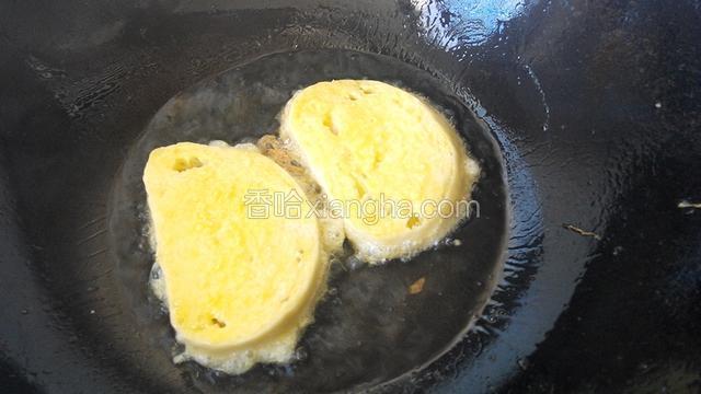 把馒头片放入鸡蛋液里，一反一正，让鸡蛋液均匀的沾满馒头片。记住:一片一片的放(图片忘了拍了)