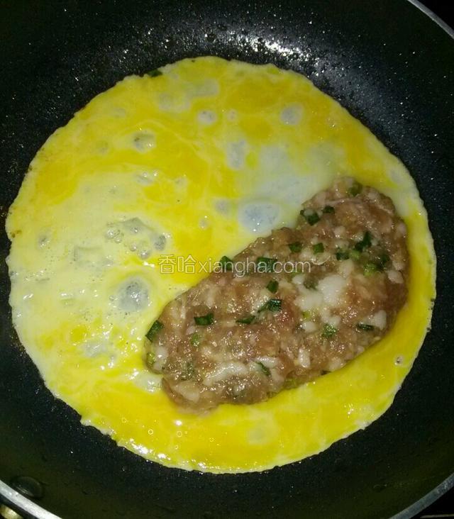 平底锅刷少许玉米油中小火加热，鸡蛋一个碗里打散倒入平底锅，稍微摇一摇锅使其摊圆，转小火将一分肉泥放于鸡蛋皮的一侧，用小勺子整一下成小半圆形