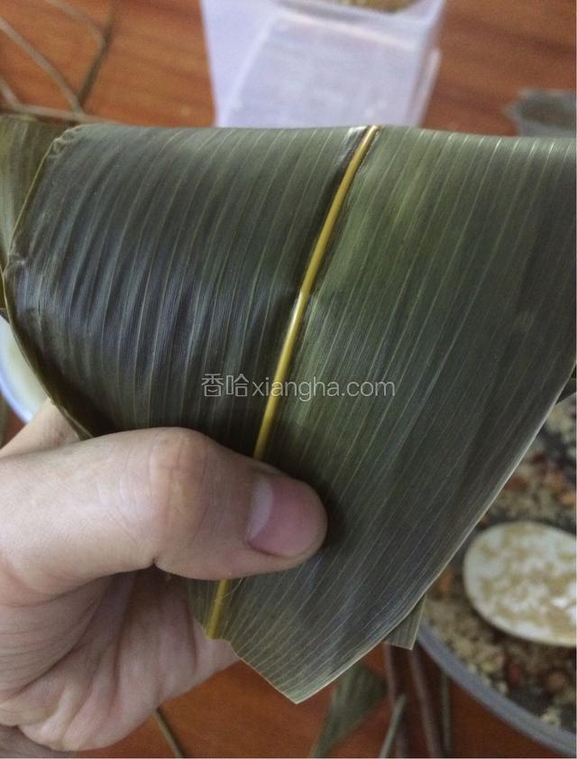 把漏斗粽叶高的一边往回折，折成三角形状！