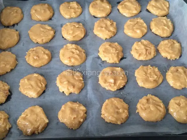 用小勺子舀少量面团，直接在烤盘的油纸上整理成一个个小桃酥形状；