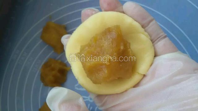 取一块酥皮轻轻按扁，包入馅料收口
