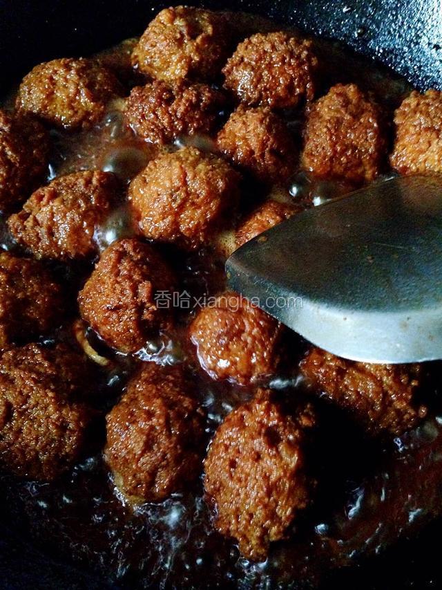 如图所示：把炸好的肉圆放入炒锅里加入适量的水，生姜片，生抽(多一点)和老抽(少一点)，白糖，一起调味，大伙煮开后小火炖20分钟，再开大伙收卤汁。就可以关火出锅了。