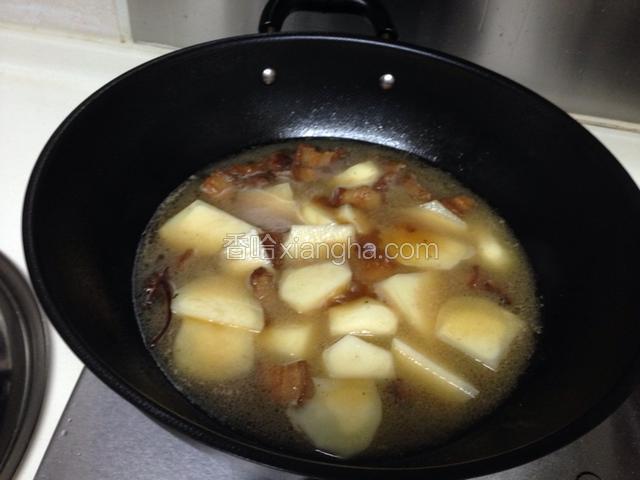 红烧肉炖煮20分钟后，将土豆放入锅内