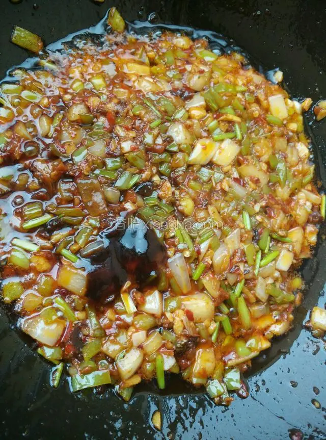 如图所示：豆瓣酱炒出红油后，加人一汤匙酱油，一汤匙蚝油；