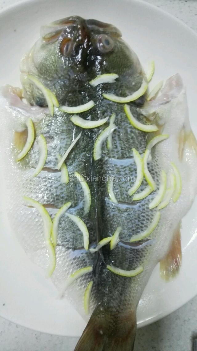 用两勺盐，两勺酒将鱼淹半小时。柠檬切3片备用，剩下的柠檬，将汁水挤出备用。柠檬还有用o，挤出汁水的柠檬将心去掉，皮切细丝放在淹起的鱼上！