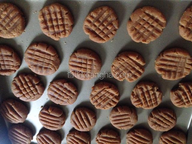 取10克一份,搓圆。压扁,用叉子压出花纹。放入烤盘