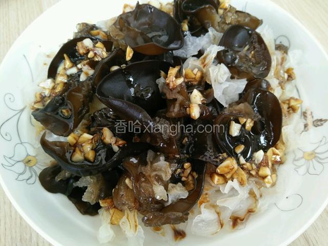 将控好水的木耳和银耳装在盘子里然后把碗汁均匀的浇在上面