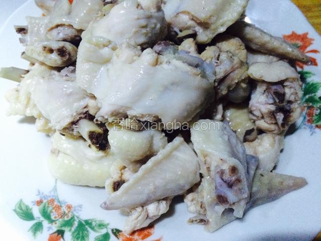 鸡翅煮好后捞在冷水盆里浸泡降温，之后洗净浮沫，攥干水分放在一个盘子里备用；