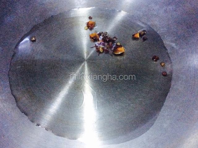 起锅小火放油，同时放入花椒粒和八角瓣，炸出香气后捞出花椒粒和八角瓣不要；
