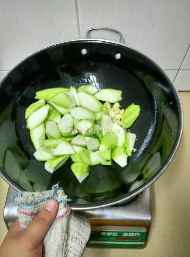 锅内余油下入大蒜炒出香味，下入丝瓜煸炒！