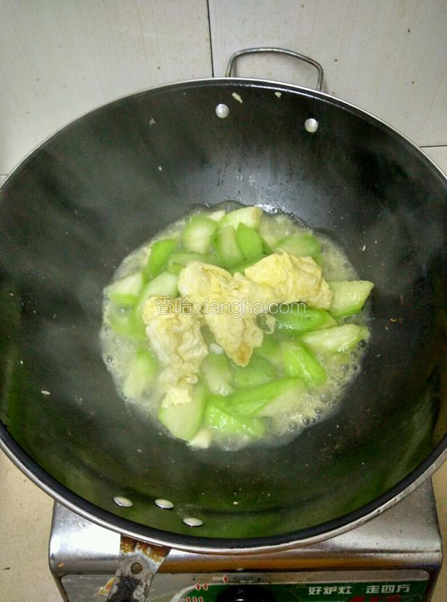 待丝瓜出水后，下入炸好的鸡蛋，翻炒！然后加入食盐，翻炒均匀