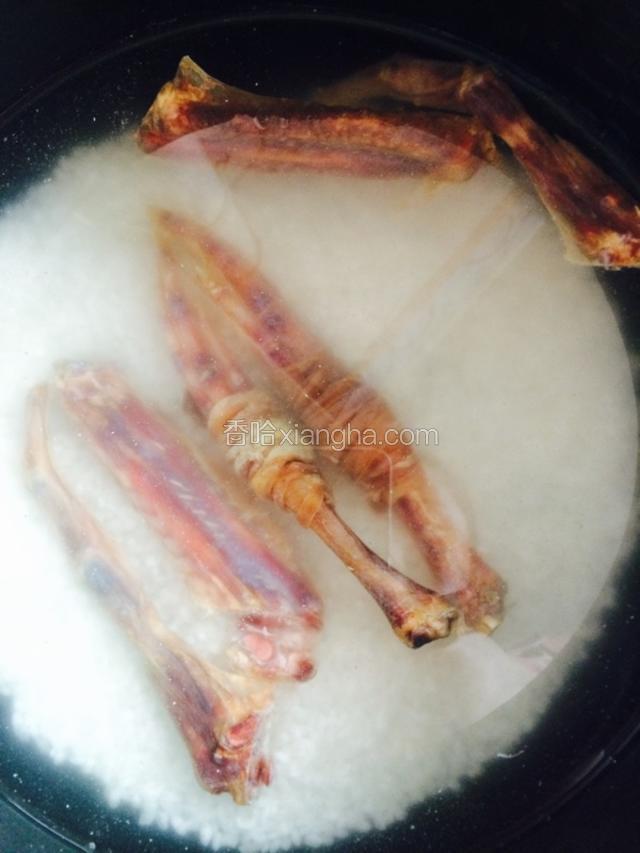 电饭锅里放米 淘干净 就像平时蒸米饭一样 不过要多放一点水 把鸭脚包和鸭翅放上面 上锅蒸