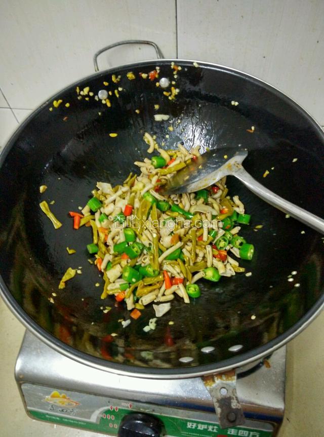倒入辣椒和酸豆角，继续翻炒至均匀！