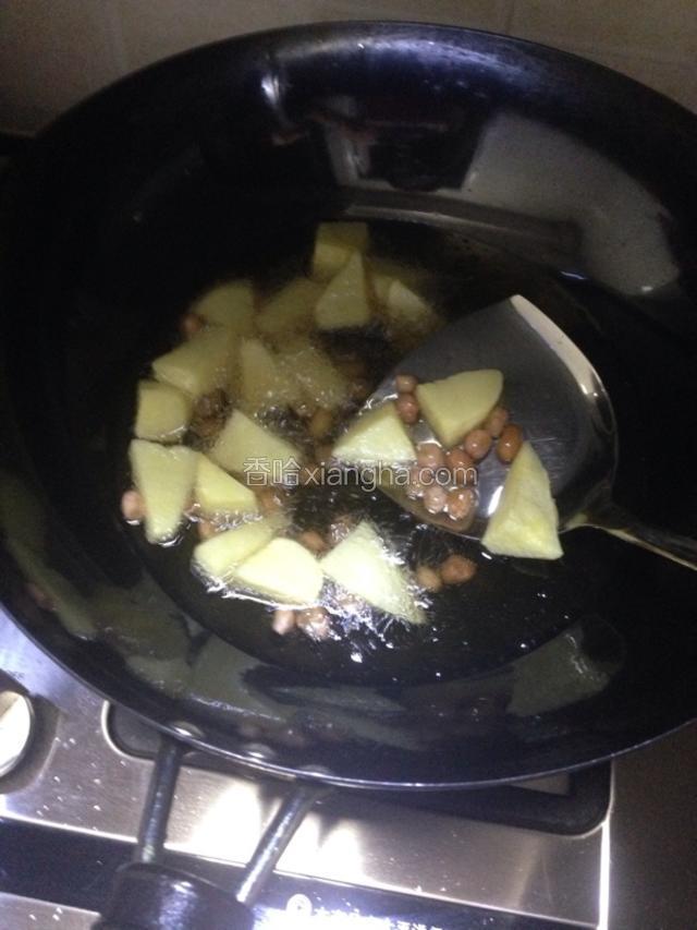 倒入花生油，要等油热才能把土豆，花生放油里炸，炸成金黄色就行了，调中火哦