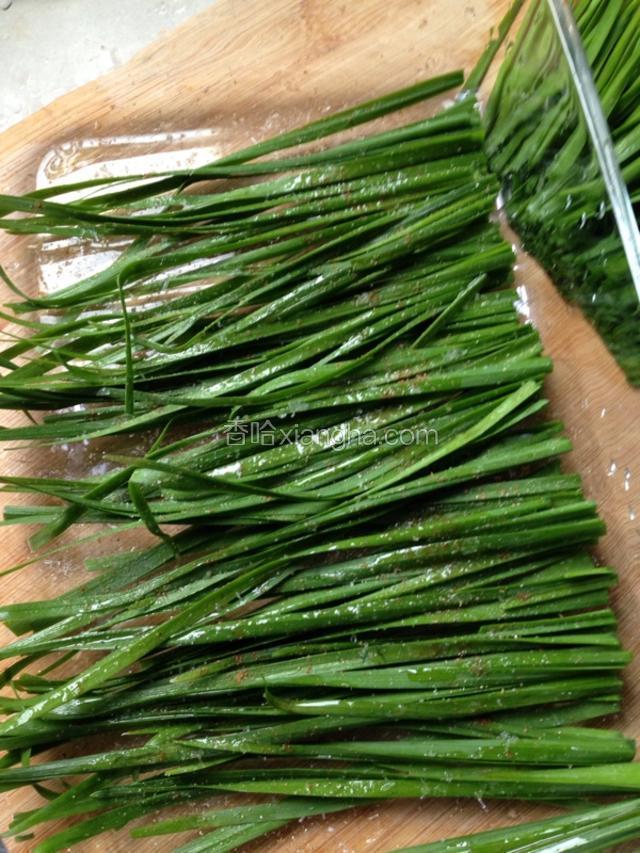 用一个微波炉盘，先把尾部的韭菜铺在盘子里，刷上花生油，撒上少许椒盐，孜然粉，五香粉