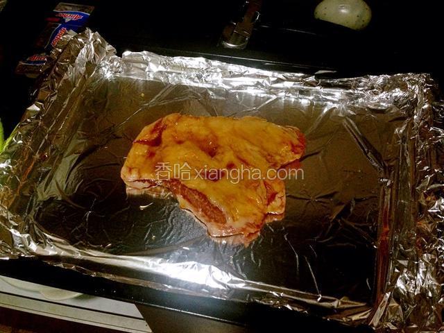 三小时后把猪颈肉从冰箱取出，烤盘铺上锡纸，把腌制好的猪颈肉铺到锡纸上。