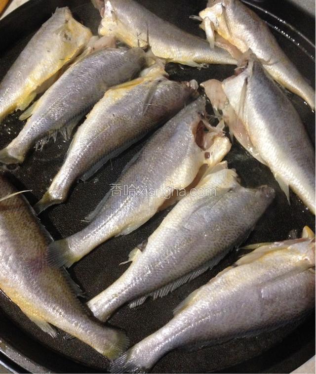 把小黄鱼清洗干净，沥干水分，电档锅加入适量的食用油，把鱼整齐的放好，先煎好一面再把鱼翻身，把另一面也煎黄，就可以了。