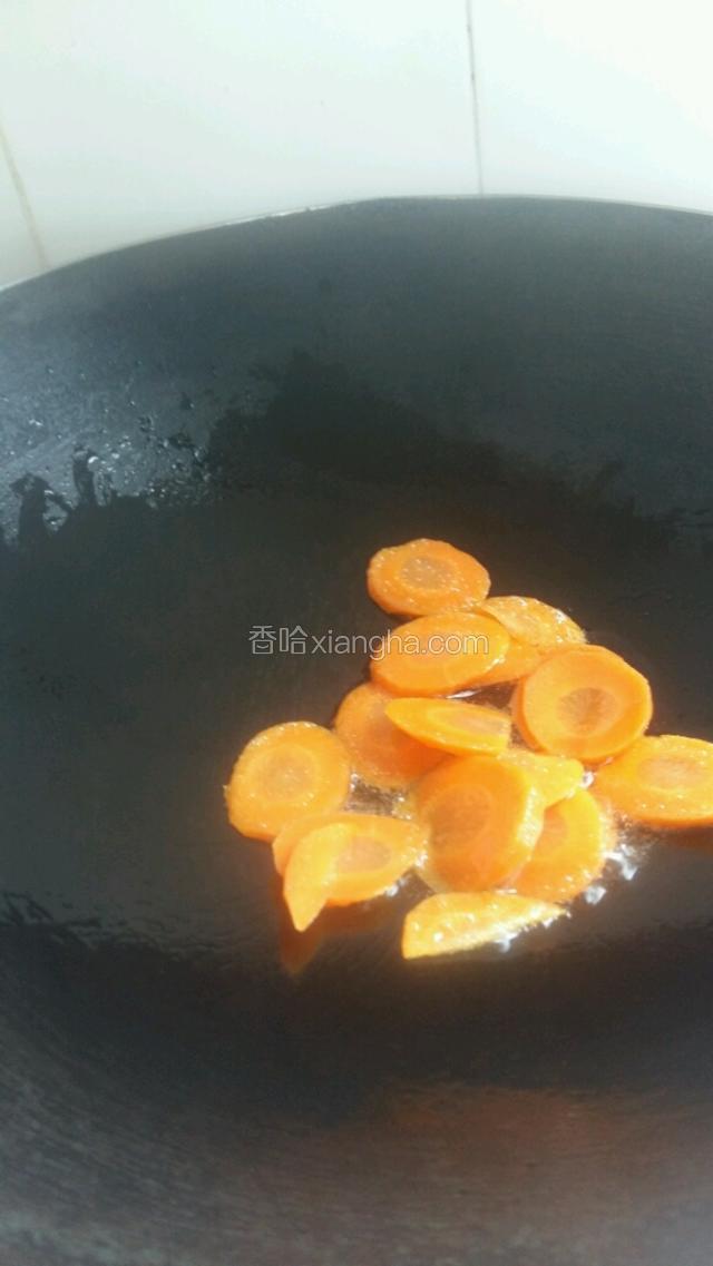 锅炒热，倒入适量花生油。待油五成热，倒入胡萝卜翻炒几下。