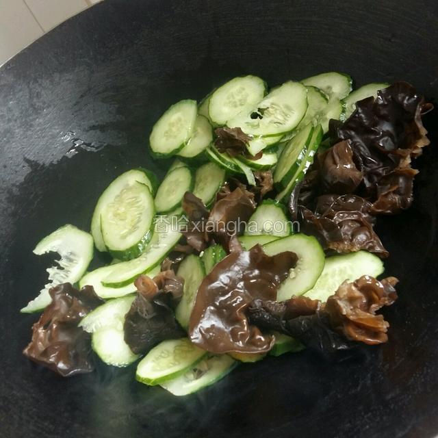 锅热，倒入适量花生油。待油五成热，倒入黑木耳，青瓜一起翻炒几下。盛出装盘备用
