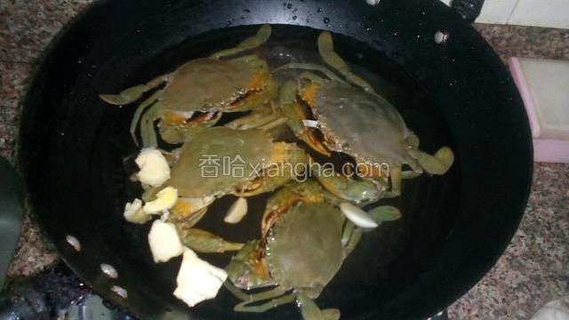 把蟹放入锅中，加盐，姜片，大蒜，料酒
