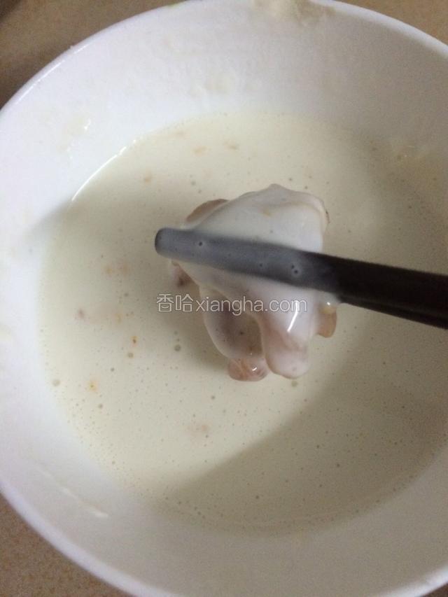 用筷子夹起鸡块，裹一层面糊…