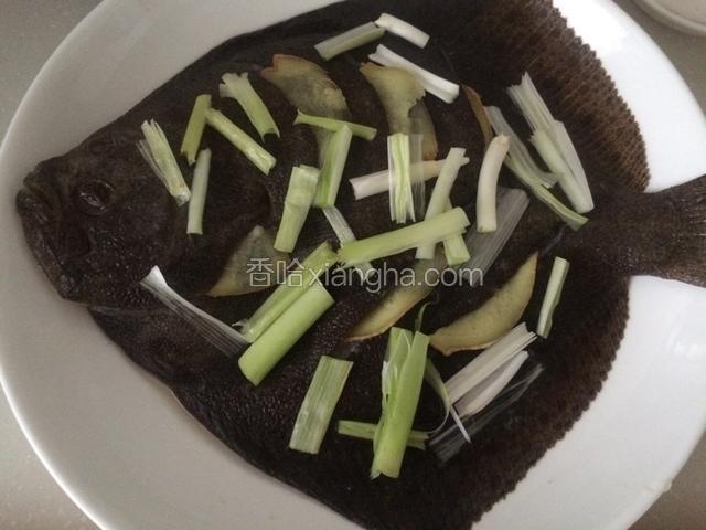 把姜片分别塞入鱼身切口处、腹中和鱼头位置，葱白段均匀撒在鱼身上，待蒸锅里水烧开后，把鱼放里；