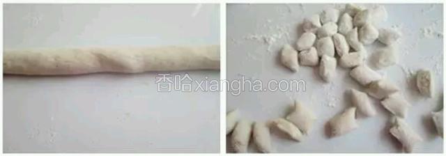 操作台上撒些木薯粉，芋艿面团取一小块，搓成细长条切小段，撒些木薯粉防粘连