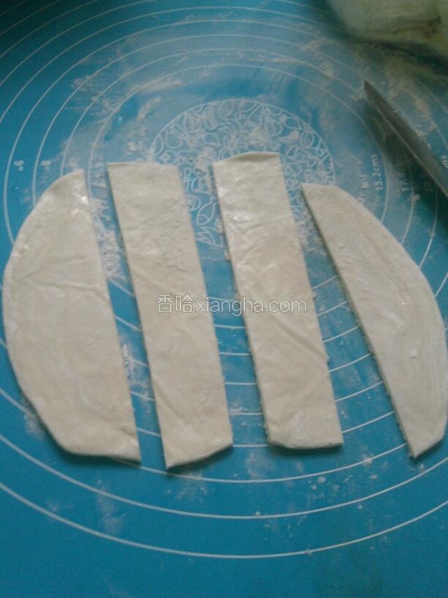 按板上撒面粉，饼皮分四份切开