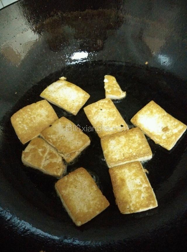 倒少许油在锅中，待油温升高，把切好的豆腐块放入锅中煎。开小火，把豆腐块两面煎至金黄色。然后装盘。