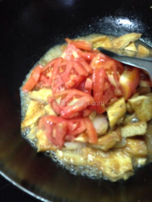 下入西红柿炒匀后加半小碗开水，焖至豆腐和西红柿变软，调入少许白糖、适量盐稍焖入味。