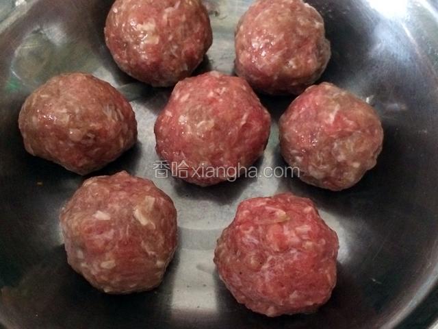 用肉馅包裹肉皮冻，整理成丸子形状，双手反复轻轻摔打，把肉丸弄圆，弄实，摆放在盘子里，盘子底部要涂抹一层清水；